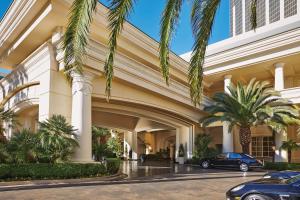 un bâtiment avec des palmiers et des voitures garées devant dans l'établissement Four Seasons Hotel Las Vegas, à Las Vegas