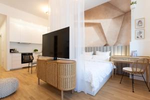 a bedroom with a bed and a flat screen tv at The Bohemian Courtyard Studios in Vienna