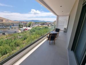 balcón con mesa, sillas y vistas en Achillion Suites, en Lefkada