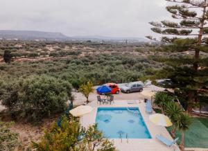 an overhead view of a swimming pool with umbrellas at Minas Farm Cottage in Gouves