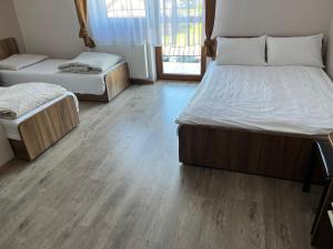two beds in a room with wooden floors at Villa Etiuda in Ustronie Morskie