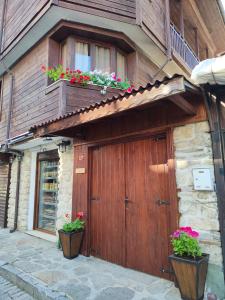 a building with a wooden garage with two potted plants at Guest Rooms Melsambria in Nesebar