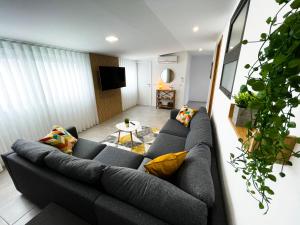 uma sala de estar com um sofá e uma televisão em House 9 Guimarães em Guimarães