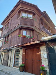 a wooden building with two balconies and flowers on it at Guest Rooms Melsambria in Nesebar