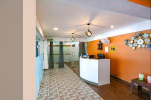 an office with orange walls and a reception desk at FabHotel Skylight Inn Near Medanta Hospital in Gurgaon