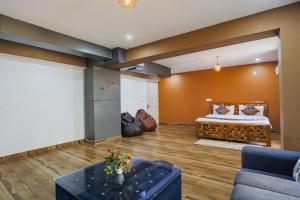 uma sala de estar com uma cama e um sofá em FabHotel Skylight Inn Near Medanta Hospital em Gurgaon