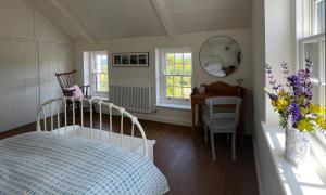 a bedroom with a bed and a table and a mirror at Dyffryn in Newport Pembrokeshire