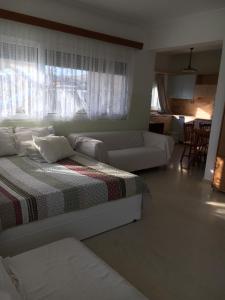 a white bedroom with a bed and a couch at Eva Rooms in Preveza