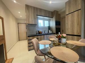 uma cozinha com mesa e cadeiras num quarto em AGORA luxury APARTMENT 3 em Loutraki