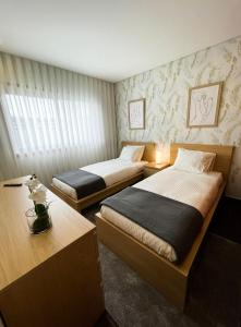 um quarto com duas camas e duas mesas em House 9 Guimarães em Guimarães