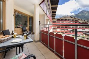 een balkon met een tafel en uitzicht op een gebouw bij Spacious Corner apartment in Aparthotel Kleinwalsertal in Mittelberg