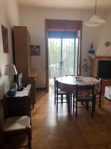 d'un salon avec une table, des chaises et une fenêtre. dans l'établissement La sirenetta bellicosa, à Torre Suda