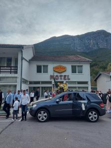Drežnjak的住宿－Motel and Restaurant Odušak，停在大楼前的街道上的汽车
