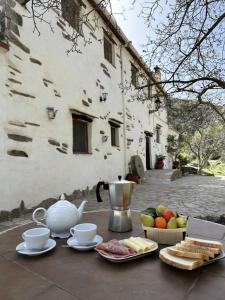 a table with a teapot and a bowl of fruit at Molino Laroya in Laroya