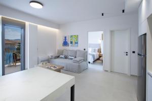 a white living room with a couch and a table at Achillion Suites in Lefkada Town
