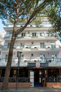 duży biały budynek z znakiem przed nim w obiekcie Hotel Kennedy w mieście Lido di Jesolo