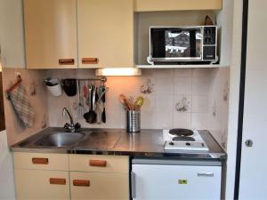 Una pequeña cocina con fregadero y microondas. en Appartement cosy à Risoul 1850 - 4 couchages, proche remontées mécaniques et commerces - FR-1-330-220, en Risoul 9 fotos más