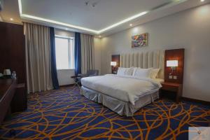 a hotel room with a bed and a desk at Quba Inn Hotel in Jazan