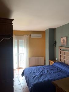 ein Schlafzimmer mit einem blauen Bett und einem Fenster in der Unterkunft Casa Rural El Gran Encanto in Cazorla