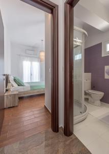 La salle de bains est pourvue d'une douche en verre et de toilettes. dans l'établissement Villa Ellania Milos, à Adamas