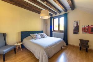 1 dormitorio con 1 cama, 1 silla y 1 ventana en L’étang des 7, en Thenay