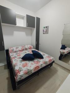 - une chambre avec un lit doté d'oreillers bleus dans l'établissement Enjoy Beach Porto Cesareo, à Porto Cesareo