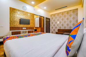 SinnarにあるFabHotel Tanishqのベッドとテレビ付きのホテルルーム