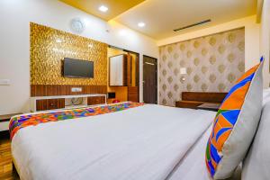 a hotel room with a bed and a tv at FabHotel Tanishq in Sinnar