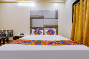 SinnarにあるFabHotel Tanishqのベッドルーム1室(カラフルな毛布付きのベッド1台付)