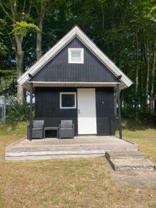 LøgstørLøgstør Camping的门廊上带两把椅子的黑白棚