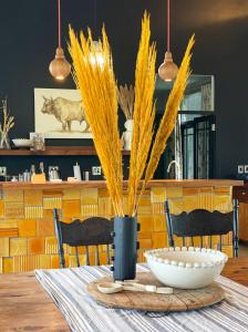 a table with a vase with yellow plants on it at Rockwood Karkloof Farm House and Farm Cottage in Howick