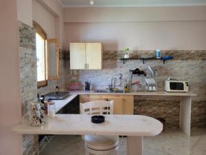 a small kitchen with a table and a microwave at Villa Medinet Habu avec piscine privée in Luxor