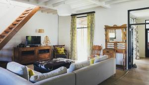 a living room with a couch and a tv at Rockwood Karkloof Farm House and Farm Cottage in Howick
