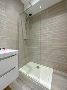 y baño con ducha, bañera y lavamanos. en Parkway residences, en Londres