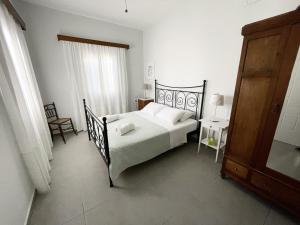 a bedroom with a bed and a table and a chair at Villa DALI Danae in Fira