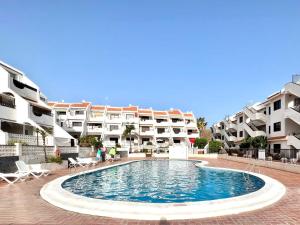 a large swimming pool in front of some apartment buildings at Quiet Coral Mar in Arona