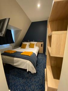 1 dormitorio con 1 cama grande con almohadas amarillas en L'Huitrière en Quiberville
