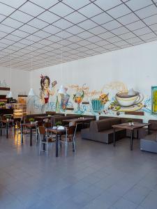 un restaurante con mesas y sillas y un mural en OWR Universal, en Łazy