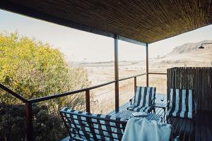 two chairs on a porch with a view of the desert at Rockwood Karkloof Farm House and Farm Cottage in Howick