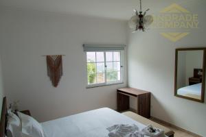 a white bedroom with a bed and a mirror at Solar da Calçada in Pinhão