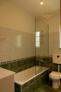 een badkamer met een bad, een toilet en een wastafel bij Casa da Calçada Guest House in Pinhão