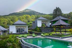 a villa with a swimming pool and mountains in the background at Batur Green Hill in Kintamani