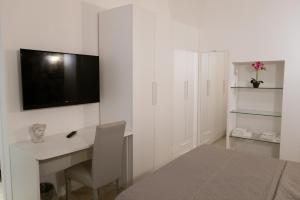 a white room with a desk and a tv on a wall at Bed and Breakfast: Nonna Rosa in Bitonto