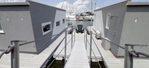 a dock with a boat in the water at Marina degli Estensi Floating Resort in Lido degli Estensi