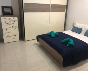 1 dormitorio con 1 cama con 2 almohadas verdes en Stanza vicino Paceville e San Giuliano, en Is-Swieqi