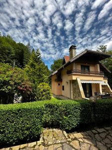 a house with a hedge in front of a building at Вила 11 - семейна почивка в сърцето на Балкана in Ribarica