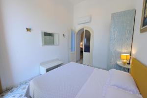 a white bedroom with a white bed and a hallway at Casa Patty...Breath-taking view! in Positano