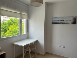 um quarto branco com uma mesa e uma janela em Apartamento en San Fernando centro em San Fernando