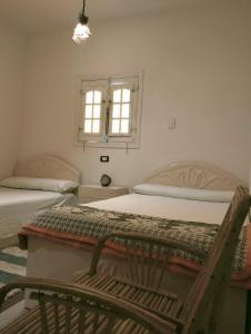 a bedroom with two beds and a window at Friendo's House & Hot Spring in Siwa