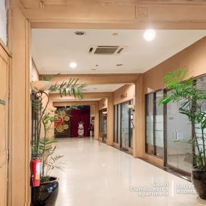 un couloir avec des plantes en pot dans un bâtiment dans l'établissement Ciumbuleuit Apartment by Secret Rooms, à Bandung